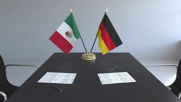 Flags of Mexico and Germany and Papers on the Table