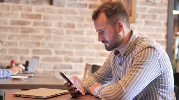 Beard Casual Man Celebrating Win on Smartphone