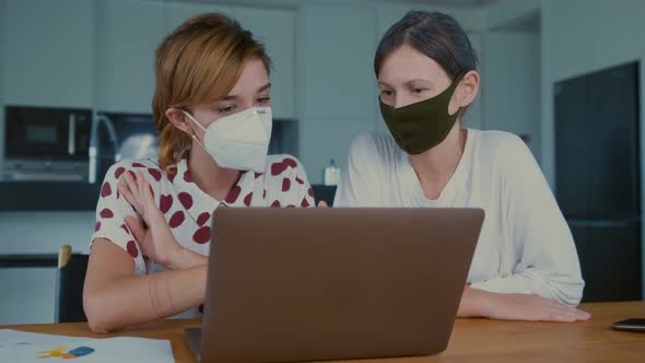 Two Caucasian Woman in Medical Masks Talking Video Link in Laptop with Doctor