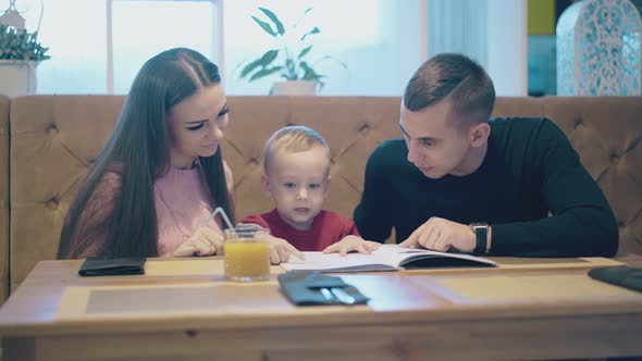 Man in Black Pullover with Wristwatch Listens To Child