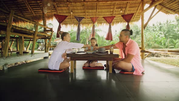 The Happy Family Eat and Drink Tasty Beverages Spending Time in Local Floating Cafe on Water