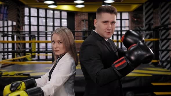 Portrait of Businessman and Woman in Business Suits with Boxing Gloves