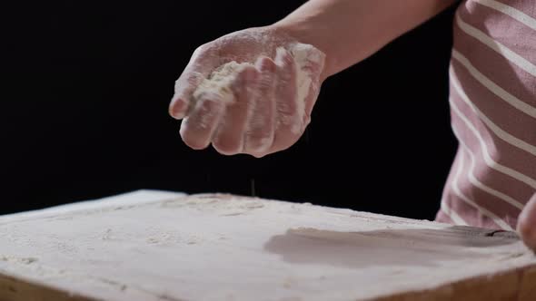 Woman Sprinkles Flour on Wooden Board for Making Pastry