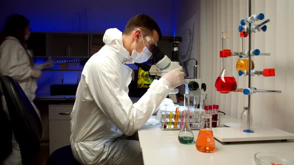 Scientist Examining Samples with Microscope