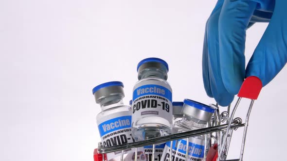 Glass vials for Covid-19 vaccine in shopping cart on white background.