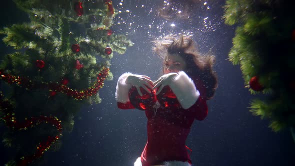 A Girl in a Red Christmas Sexy Costume, She Is Under Water on a Blue Background, Around Her Two