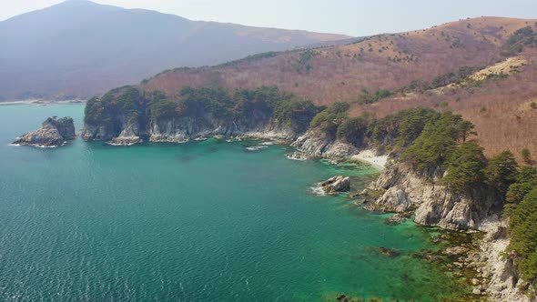 Rocky Island and a Cape in a Beautiful Bay Covered with Coniferous Trees