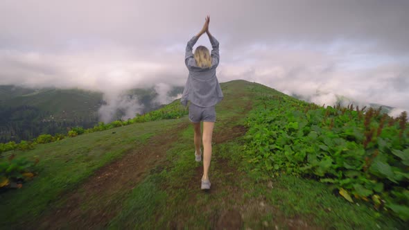 the girl walks on tops of mountains. Amazing atmospheric moment