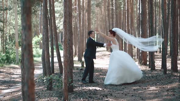 Bride in a Wedding Dress Jumps Into the Hands of the Groom the Action Takes Place in the Forest Slow