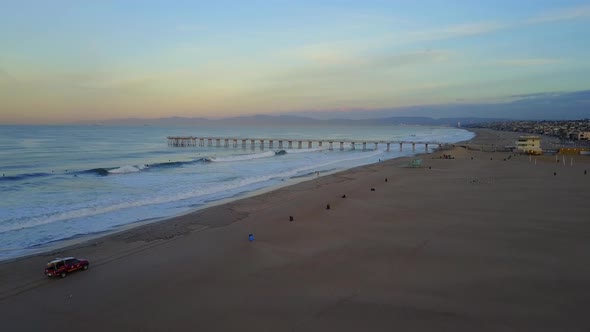 Aerial drone uav view of a lifeguard tower, pier, beach and ocean.