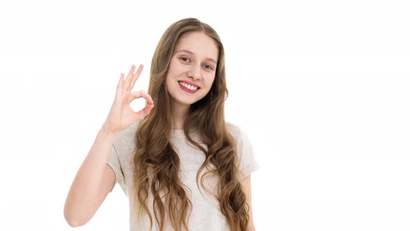 Closeup Portrait of Cheerful Student Girl Looking at Camera with Smile and Gesturing on Camera with