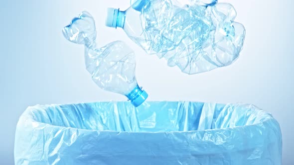 Super Slow Motion Shot of Crumpled Plastic Bottles Falling Into Trash Can at 1000Fps