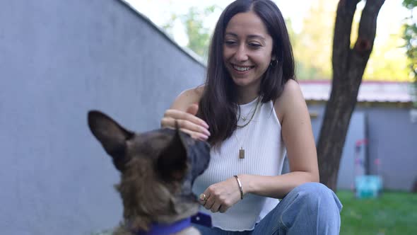 Woman Plays with a Cute Puppy on Her Lap