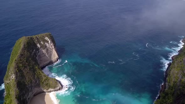 Great aerial view flight panorama overview drone shot over clouds very highKelingking Beach at Nusa