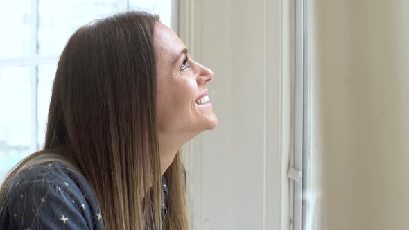 Woman looking outside through the window