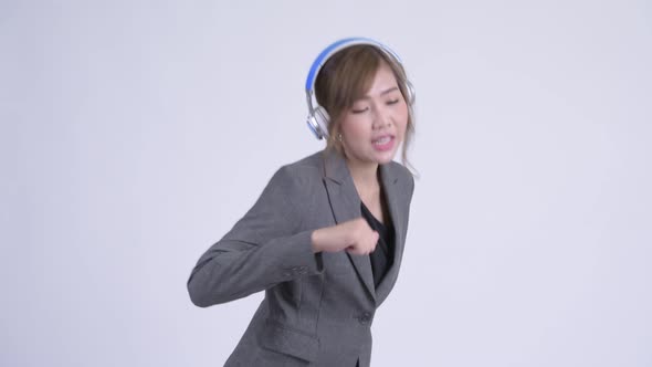 Young Happy Asian Businesswoman Listening To Music and Dancing