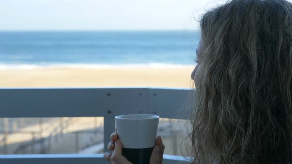 Girl Sits on Hotel Balcony with Notebook and Surfs Internet