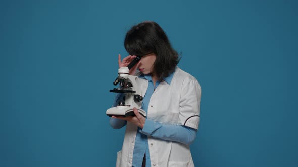 Chemistry Researcher Using Microscope with Magnifying Glass