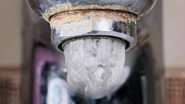 Water Flows From an Old Contaminated Tap with Calcium and Grime Into a Sink