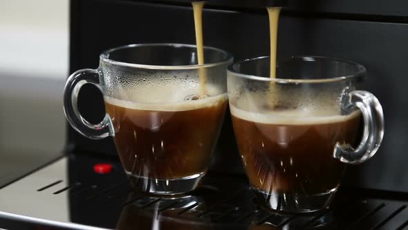 Coffee From the Coffee Machine Is Poured Into Glass Cups