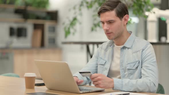 Successful Online Payment on Laptop By Creative Young Man