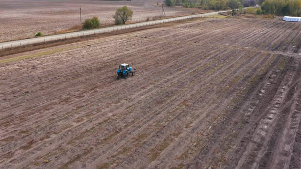 A Tractor Plows a Field in the Fall. Preparing the Land for Winter. Aerial Footage