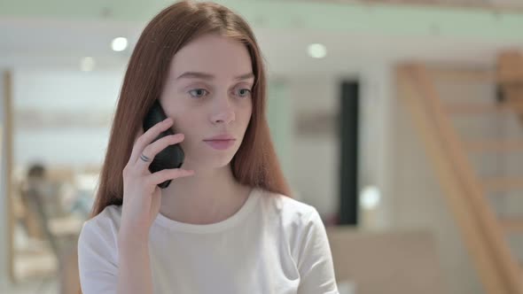 Portrait of Cheerful Redhead Young Woman Talking on Smartphone