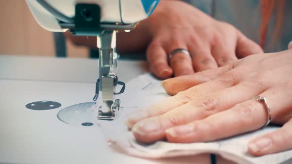 Hands of seamstress using sewing machine