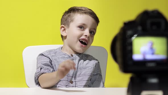 Child blogger videotapes his vlog at home. Boy recording his video blog