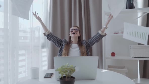 Happy Businesswoman Throwing Report Paper in a Bright Office