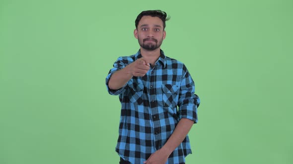 Happy Young Bearded Persian Hipster Man Pointing at Camera