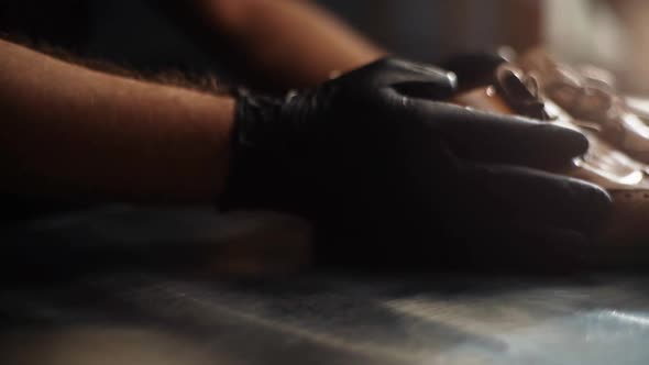 Closeup of Shoemaker Craftsman Puts Old Worn Light Brown Leather Shoes on Table to Be Repaired