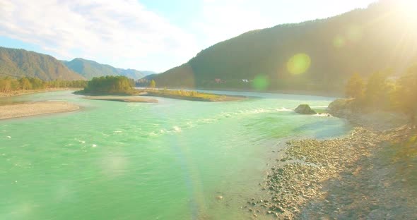 Low Altitude Flight Over Fresh Fast Mountain River with Rocks at Sunny Summer Morning.