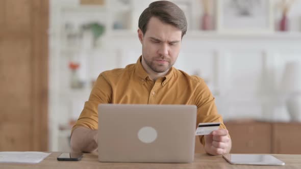 Young Man making Successful Online Payment on Laptop