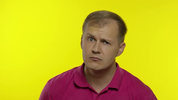 Portrait of Young Caucasian Man Posing in Pink T-shirt. Dissatisfied, Picky Guy Looking To Camera