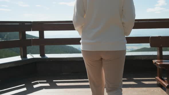 Young Woman Coming To the End of Terrace and the Amazing View on the Valley Is Opening