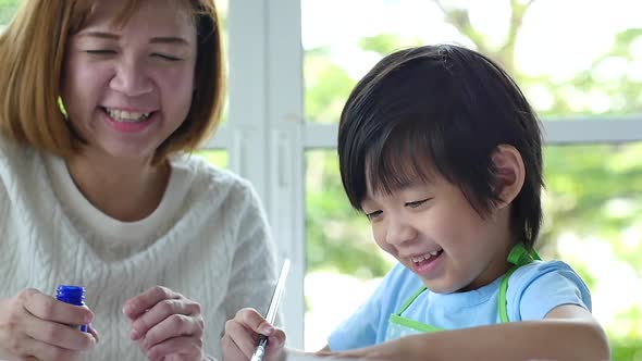 Cute Asian Child And Mother Painting Together