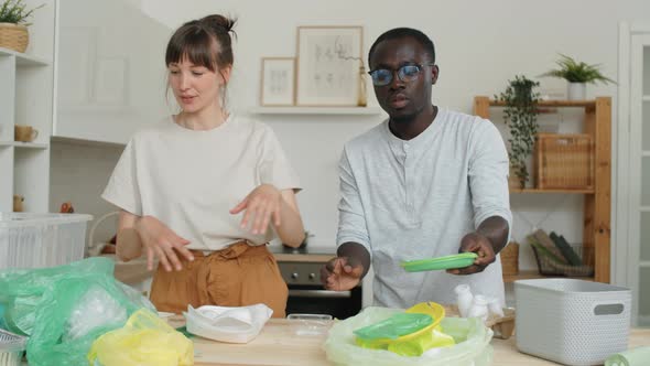 Multiethnic Couple Sorting Plastics for Recycling at Home