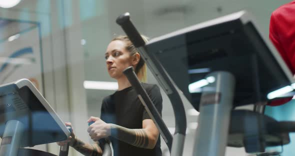 View From Window of Woman Exercising with Elliptical Walking Machine at gym.Front View, Slow Motion