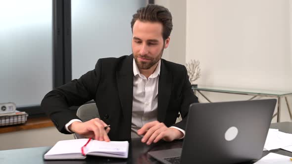 Handsome Focused Young Businessman in Formal Wear Using Laptop