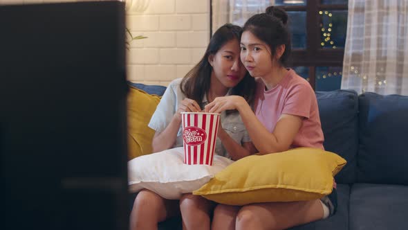 Lesbian lgbt women couple watching movie at home at night