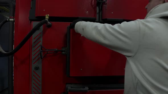 A Worker Stoker Opens the Solid Fuel Boiler Door