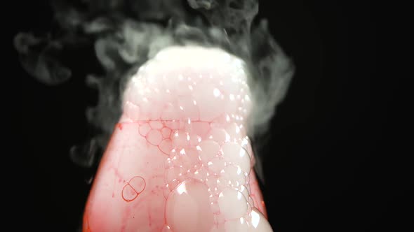 Dry Ice Bubbling in a Glass with Red Blood on a Black Background