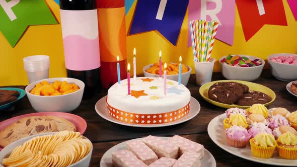 Lit Birthday Candles Cake On Table With Party Food