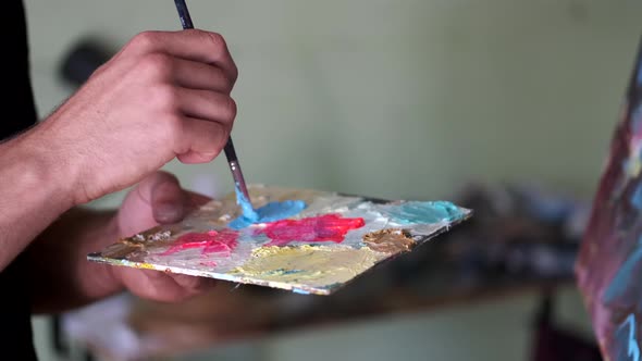 Artist Getting Ready To Paint By Mixing and Blending Paint