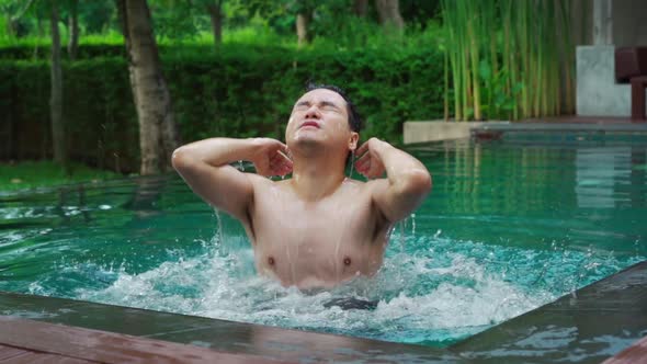 slow-motion of young man splashing water with his head