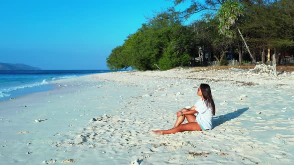 Beautiful fun women relaxing in the sun at the beach on paradise white sand and blue 4K background