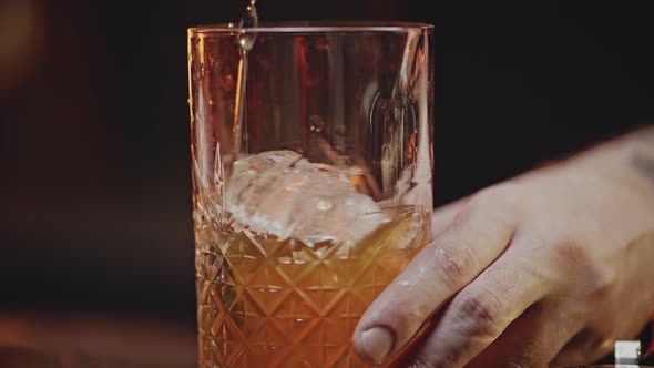 Experienced Bartender Stirs Cold Ready Cocktail in Glass