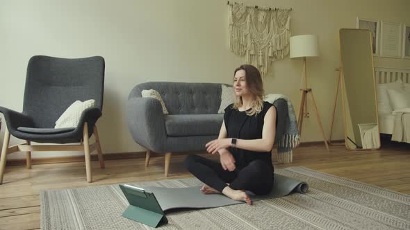 Woman with Tablet Computer Trains Yoga Stretching