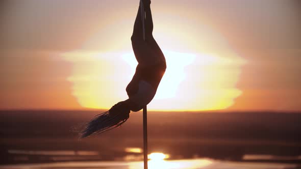 Young Woman Jumping on the Dancing Pole and Spread Her Legs on Sunset